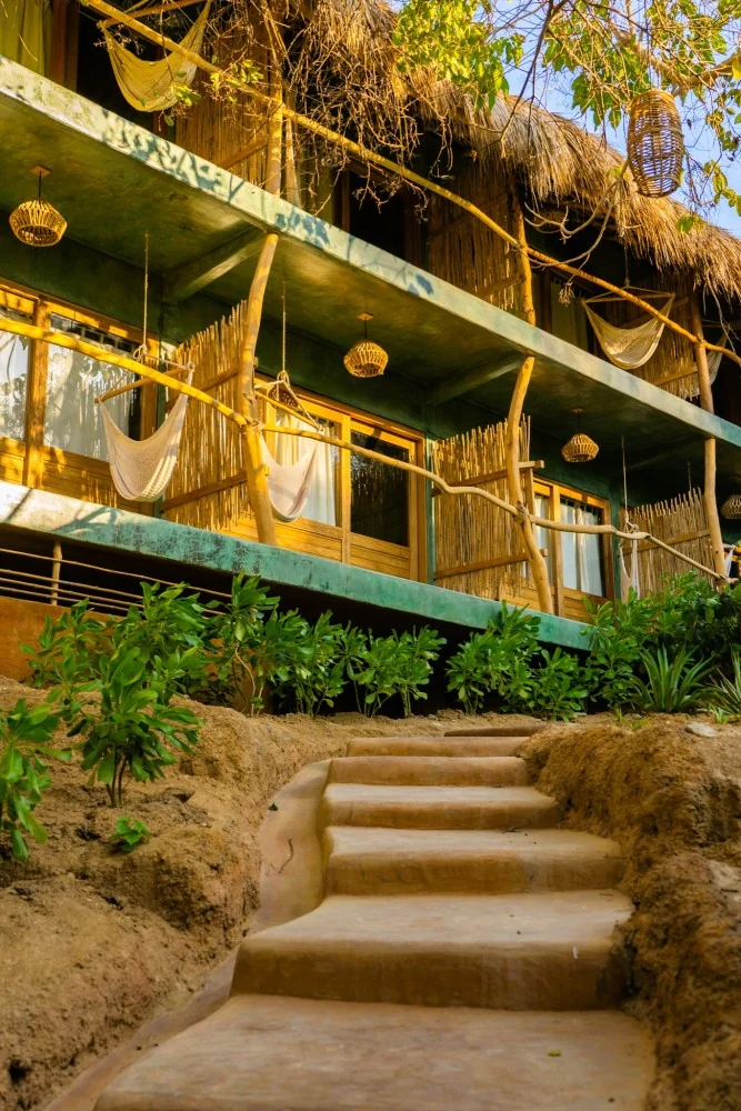 Balcones con hamacas y escalera entre la vegetación de Cocos Hotel Zipolite