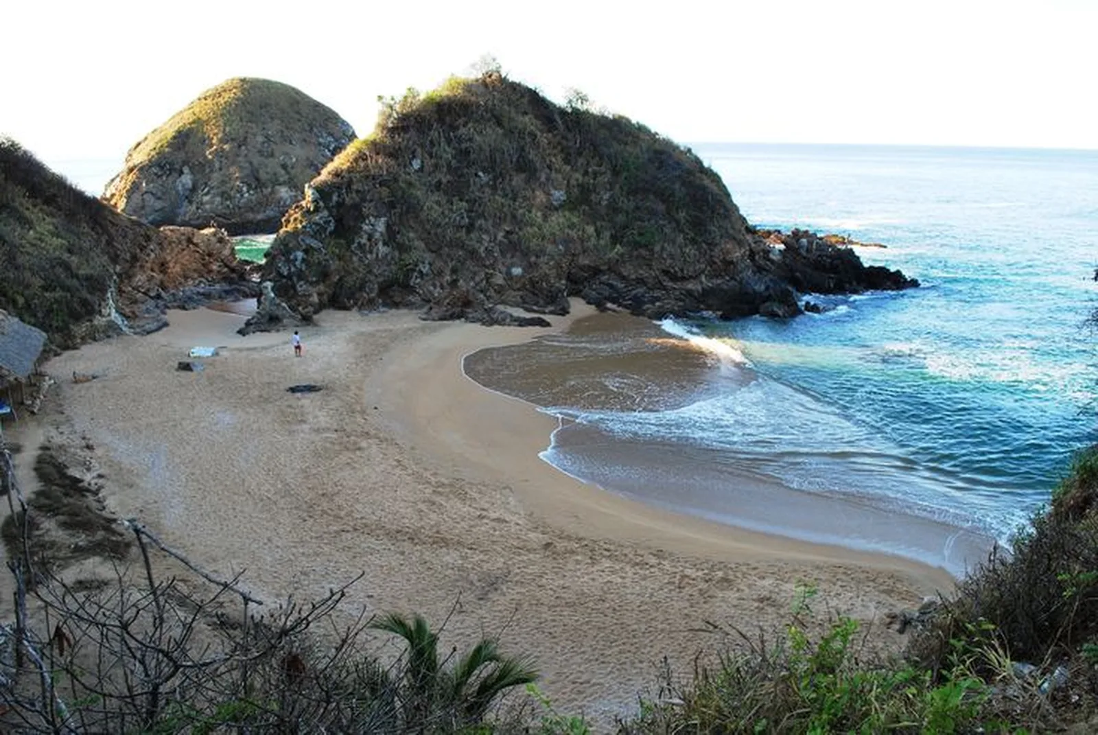Cala de Playa del Amor con arena dorada y rocas al atardecer